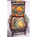 A polished as mahogany American rocking chair, upholstered in a William Morris floral fabric