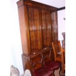 A walnut bookcase of Georgian design, the upper section enclosed three lattice glazed doors over