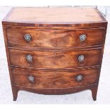 A 19th century mahogany bowfront chest of three drawers with lion mask and ring handles, on bun