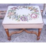 A carved walnut stool of Louis XVI design with needlepoint seat, on square taper supports united