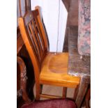 A set of eight wooden rail back dining chairs with wooden seats