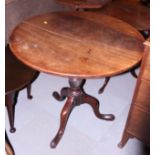A George III oak circular tilt top table, on turned column and tripod cabriole supports, 31 1/2"