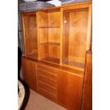 A contemporary teak lounge storage unit, fitted two glazed cupboards and open shelves over base