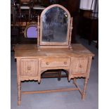 A limed oak kneehole dressing table with linen fold decoration, fitted three drawers, and a