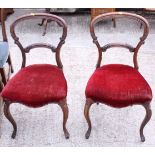 A pair of Victorian carved walnut loop back side chairs with stuffed over seats, on cabriole