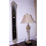 A narrow rectangular mirror, in painted frame, and a table lamp with shade