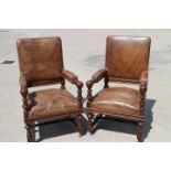 A pair of oak framed open armchairs of 17th century design, upholstered in a brown leather, on