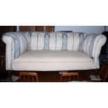 A chesterfield sofa with drop-end, upholstered in a cream, blue and floral fabric