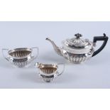 A bachelor's silver three-piece teaset with half-fluted decoration and ebonised handle and knop,