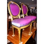A pair of Louis XVI design giltwood salon chairs, upholstered in a purple fabric