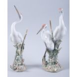 A pair of Lladro models of storks, on floral encrusted bases, 12" high