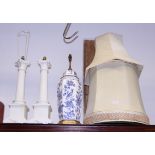 A pair of white china Corinthian column table lamps, a similar blue and white ginger jar lamp, two