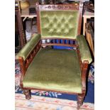 A late 19th century oak framed armchair with spindle decoration, upholstered in a green velour