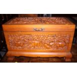 An Oriental blanket box, decorated with carved panels of elephants to top and sides, 30" wide