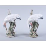A pair of Lladro models of storks, on floral encrusted bases, 8" high