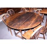 An 18th century oak oval drop leaf gateleg dining table, on turned supports, 53" x 48" when fully
