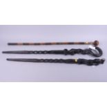 Two African wooden walking sticks, carved figures, and another walking stick, decorated plaited wire