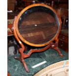 A late Victorian mahogany and inlaid oval swing frame toilet mirror, on skeleton stand, 24 1/2" wide