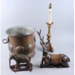 A copper coal vase, a brass elephant, a giltwood table lamp and a wooden model of a reindeer