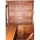 A pine kitchen dresser with boarded back, the base fitted three frieze drawers, two cupboards and