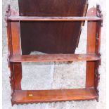 A Victorian mahogany three-tier open wall shelf with Gothic pierced sides, 23" wide, and a similar