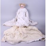 An Armand Marseille porcelain head doll with sleeping eyes, AM 4DF 3200, in a white dress (heavily