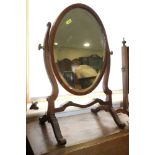 A late 19th century oval swing frame toilet mirror, on skeleton stand and splay supports, 15" x 11"