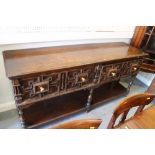 An oak dresser base of early 17th century design with fielded panelled drawers over pot board, on