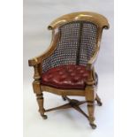 A child's early 19th century cane back scroll armchair with seat button upholstered in a leather, on