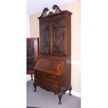A late Georgian mahogany bureau bookcase, the upper section with pierced swan neck pediment enclosed