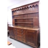 A 19th century oak dresser fitted three shelves flanked cupboards over base fitted four graduated