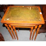 A nest of three yew occasional tables with tooled leather tops, 19" wide