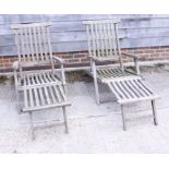 Two teak steamer chairs, with cushions, and a teak garden table