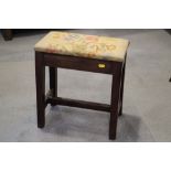 A 19th century mahogany stool with needlework seat, on stretchered supports, 15" wide