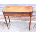 An early 19th century mahogany and rosewood banded and line inlaid fold-over top card table, on faux