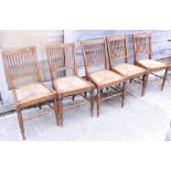 Five oak rush seat chairs, on turned supports, and a mahogany chair, upholstered in a green