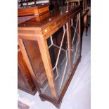 A 1920s walnut display cabinet enclosed astragal glazed panel doors on bracket feet, 42" wide