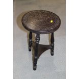 An early 20th century carved top stool, on turned supports, 11 1/2" dia