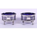 A pair of early 20th century silver salts with pierced decoration and blue glass liners, 4.6oz