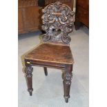 A 19th century Renaissance design carved oak hall chair with panel seat, on turned supports