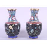 A pair of Chinese cloisonne vases with floral decoration on a dark ground, 8" high