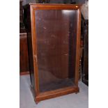 An early 20th century walnut display cabinet enclosed glazed panel door, 29" wide