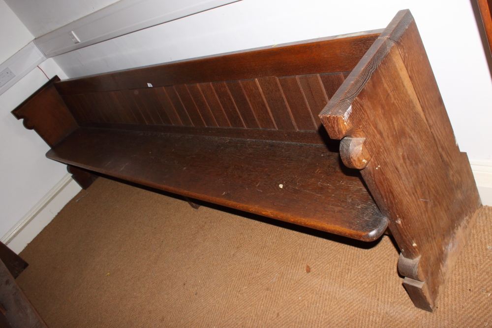 A carved oak pew with trefoil panel ends, 120" long