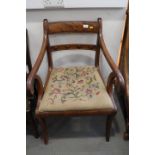 A George IV mahogany scroll arm carver chair with needlepoint drop-in seat, on sabre supports