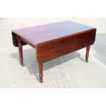 A George IV mahogany dining table with extra leaf, on turned castored supports, top 70" x 51 1/2"
