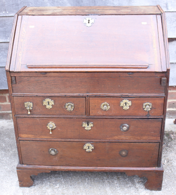 An 18th century oak provincial fall front bureau with fitted interior with well, over two drawers