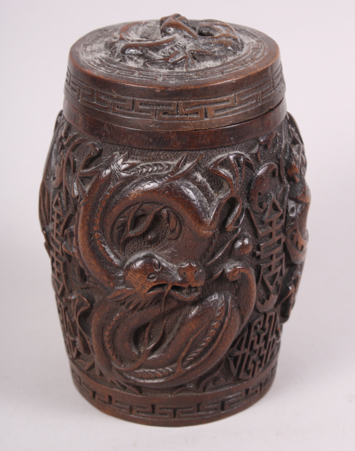 A Chinese carved hardwood drum-shaped box and cover, decorated dragons, 6" high