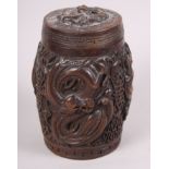 A Chinese carved hardwood drum-shaped box and cover, decorated dragons, 6" high