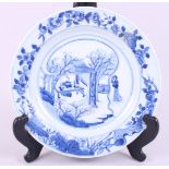 A Chinese blue and white porcelain dish, decorated figures and trees with a floral border, Kangxi