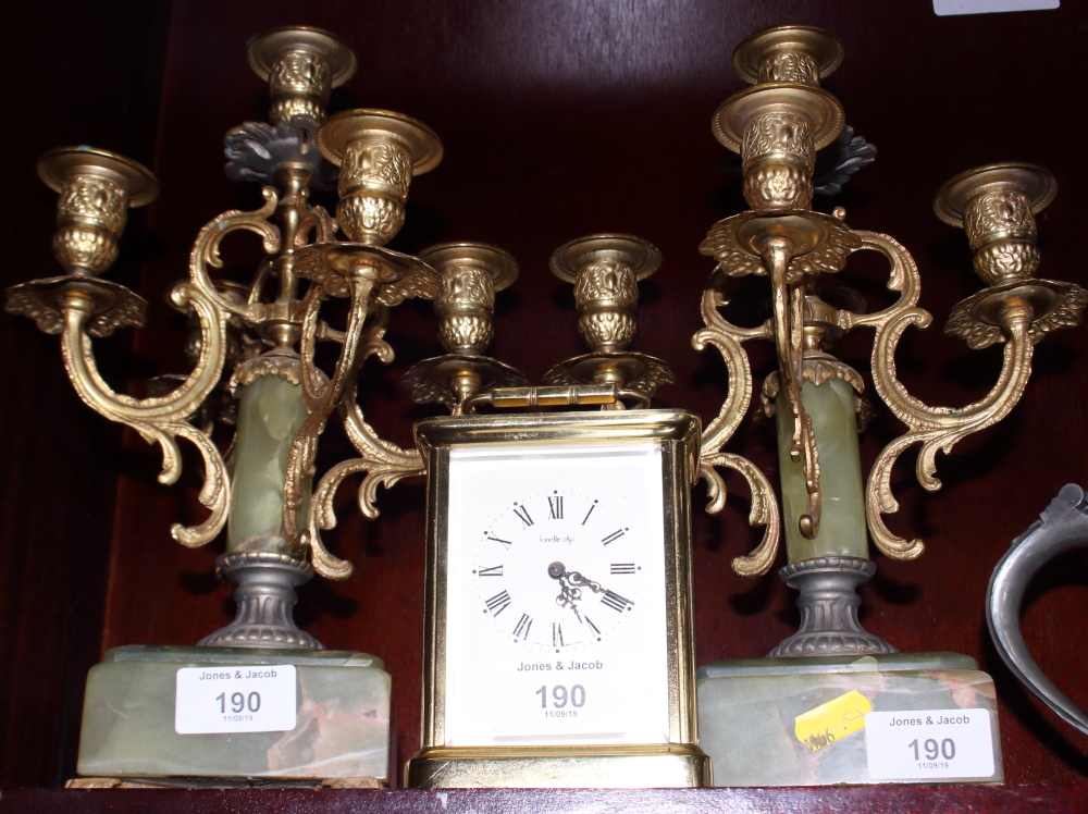 A pair of gilt metal and onyx five-branch candelabra and a Jonelle brass cased carriage clock